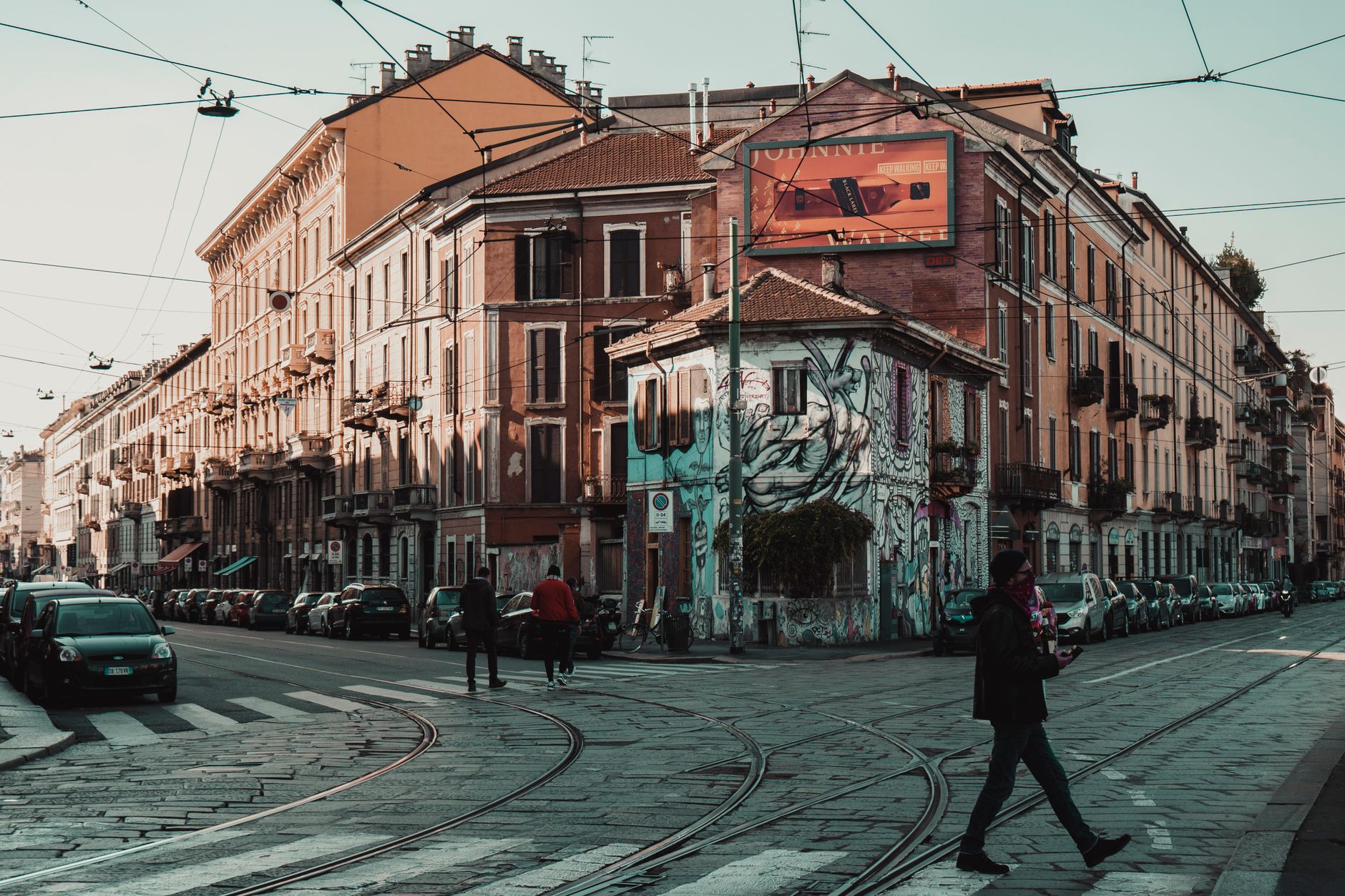 İtalya'da bir sokakta yürüyen ve telefona bakan bir kişi