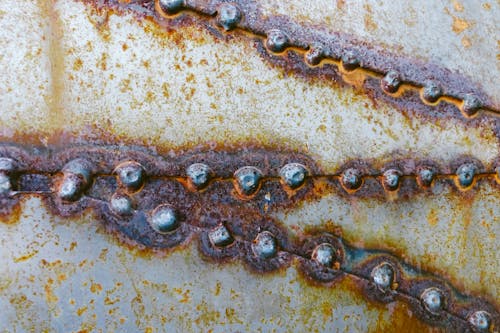 Background of old metal surface with bright rust on welding elements in shabby structure