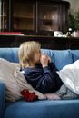 Sick Child Wiping His Nose with Tissue