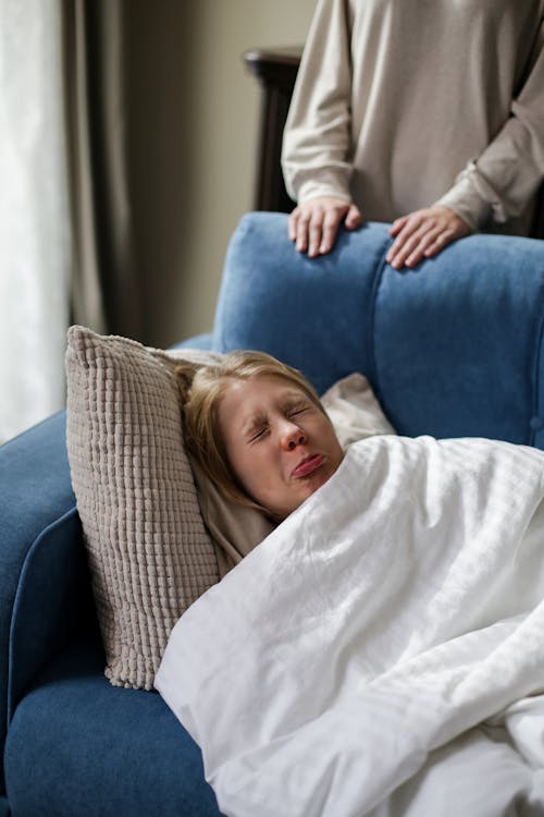 Girl in White Sweater Lying on Blue Sofa