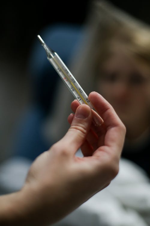 A Person Holding a Thermometer