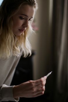 年轻女子在室内专注而沉思地检查温度计
