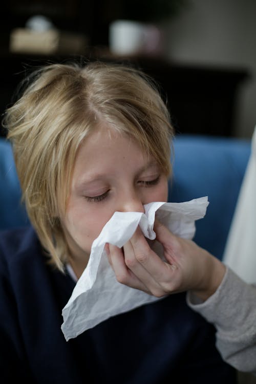 Sick Child Wiping His Nose with Tissue