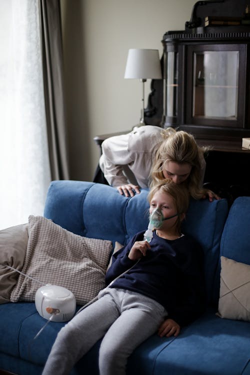 Free A Sick Boy in Blue Long Sleeves Sitting on the Couch Stock Photo