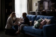 Woman in Black Long Sleeve Shirt Sitting on Blue Couch