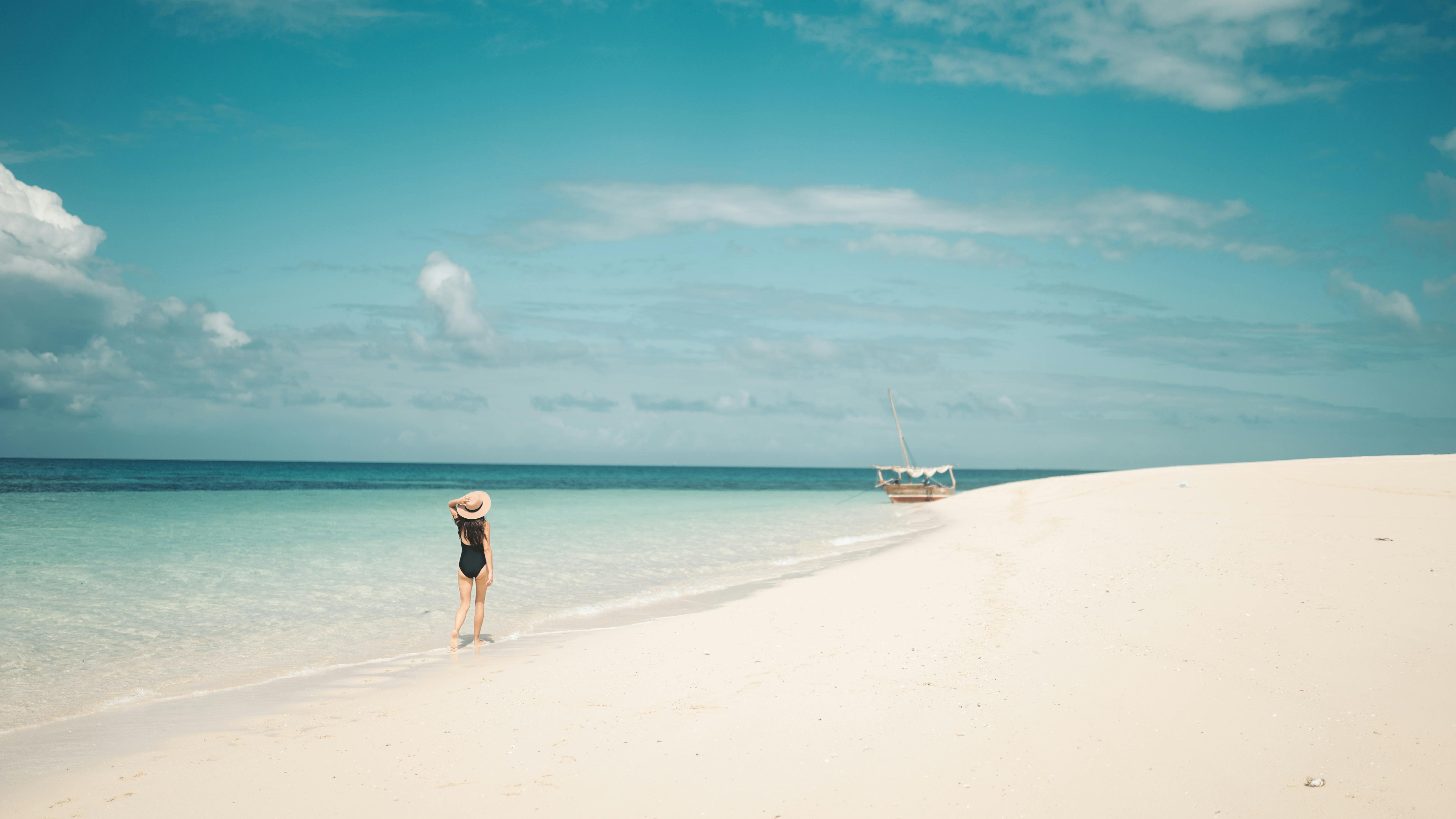 Person Sitting On White Sand · Free Stock Photo