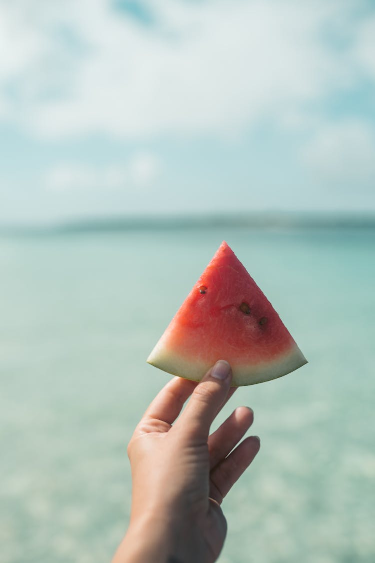 A Person Holding Sliced Watermelon Fruit