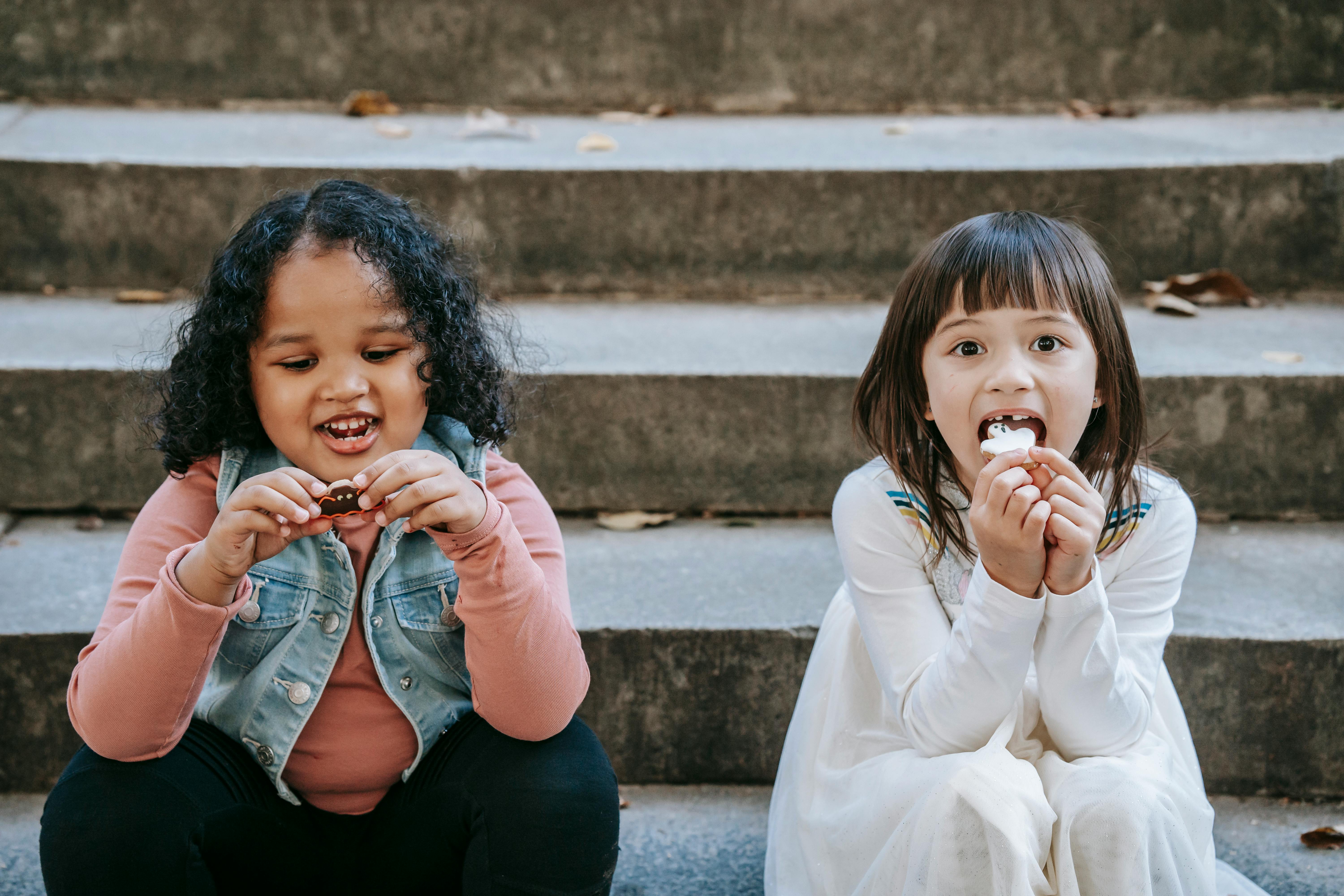 diverse kids eating ghost shaped cookies