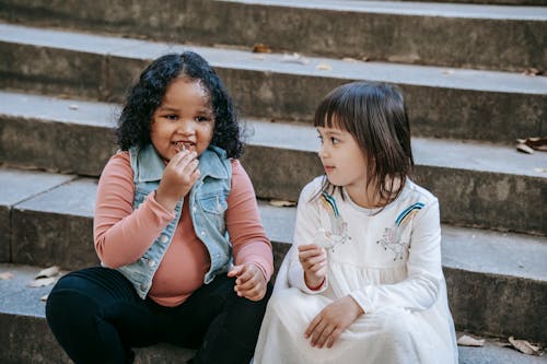 Anak Anak Multietnis Duduk Di Tangga Dan Makan Kue