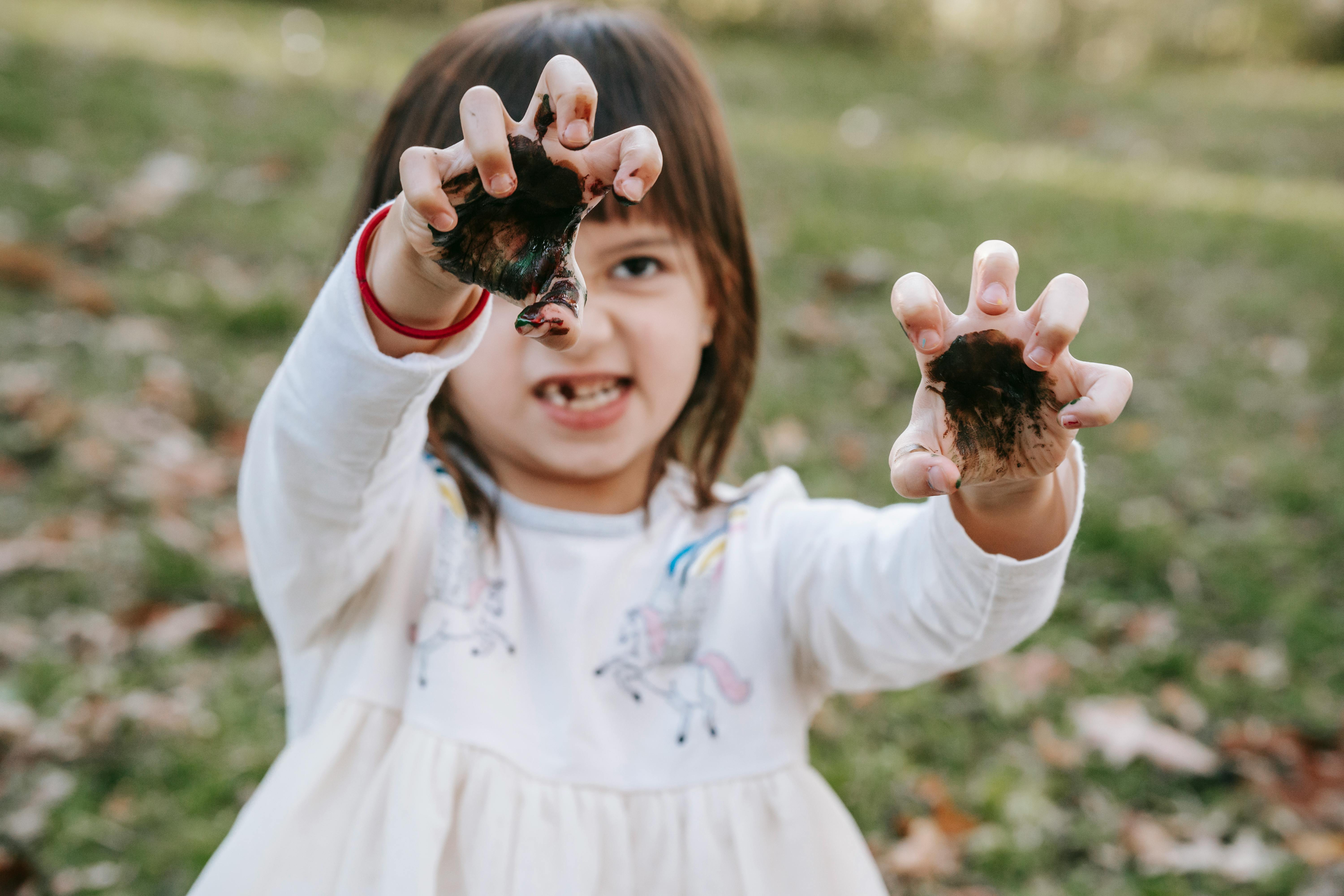 girl showing dirty hands and doing scary grimace