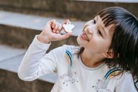 一个可爱的微笑女孩坐在石阶上，为万圣节假期做了饼干