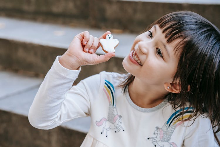 Happy Girl Showing Ghost Shaped Cookie