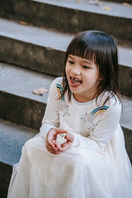 Funny girl in festive dress with sweet cookie