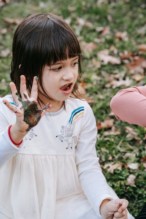 Menina Com As Mãos Pintadas Brincando Do Lado De Fora