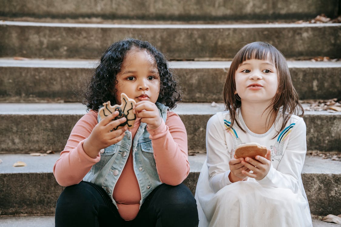 Free Little kids on steps with biscuits Stock Photo