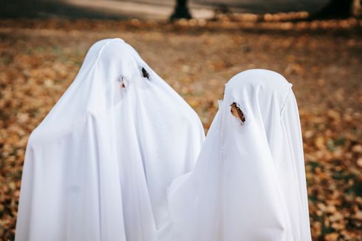 万圣节期间，公园里有一群穿着白色服装的匿名孩子，扮成令人毛骨悚然的鬼魂在玩耍
