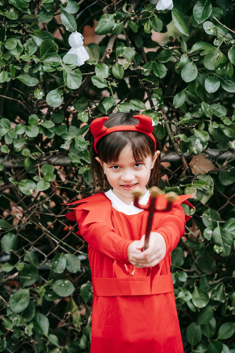 Cute Little Girl In Devil Costume With Trident