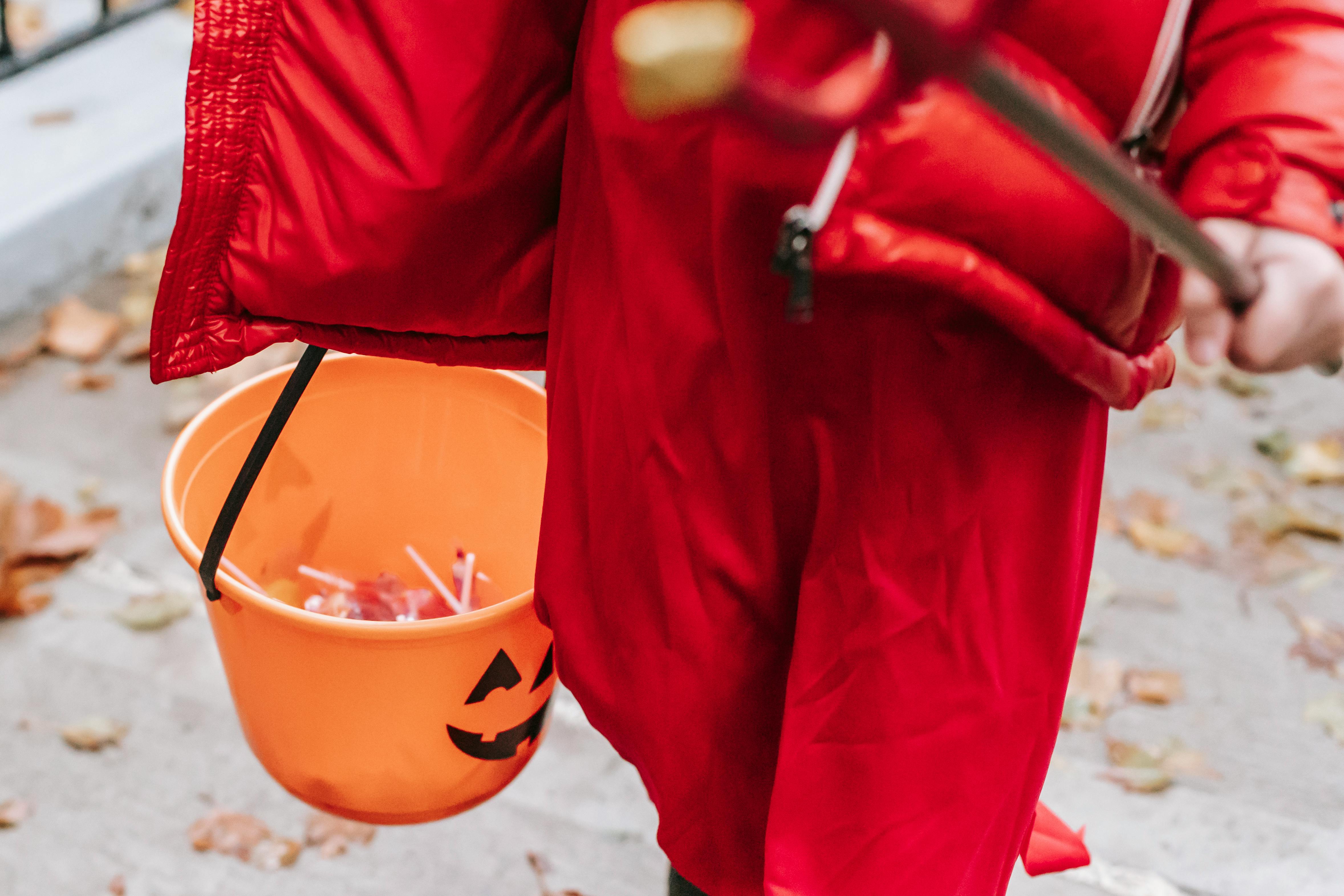 faceless child in devil costume trick or treating during holiday