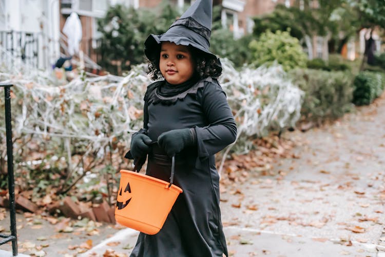 Kid In Witch Costume Trick Or Treating Outside