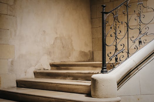 A vintage staircase with an ornate iron handrail in a historic indoor setting, exuding elegance.