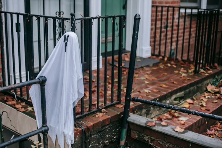 White Ghost Hanging On Railing Of Porch