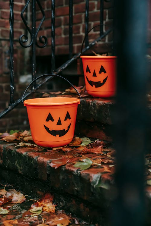 Orange buckets with Halloween symbols outside house