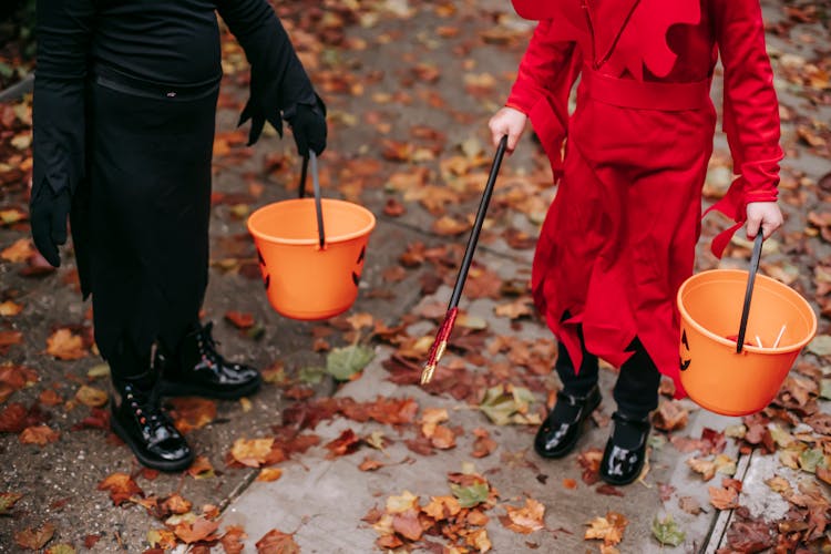 Kids Walking On Street With Buckets On Halloween