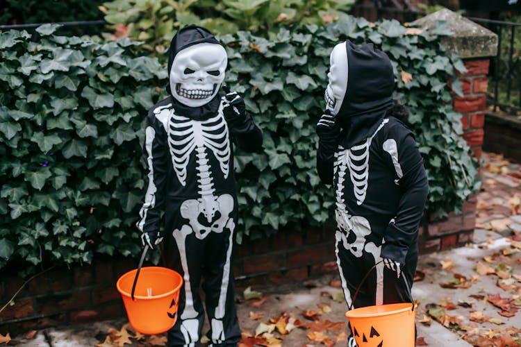 Unrecognizable Kids In Halloween Costumes Preparing For Trick Or Treat