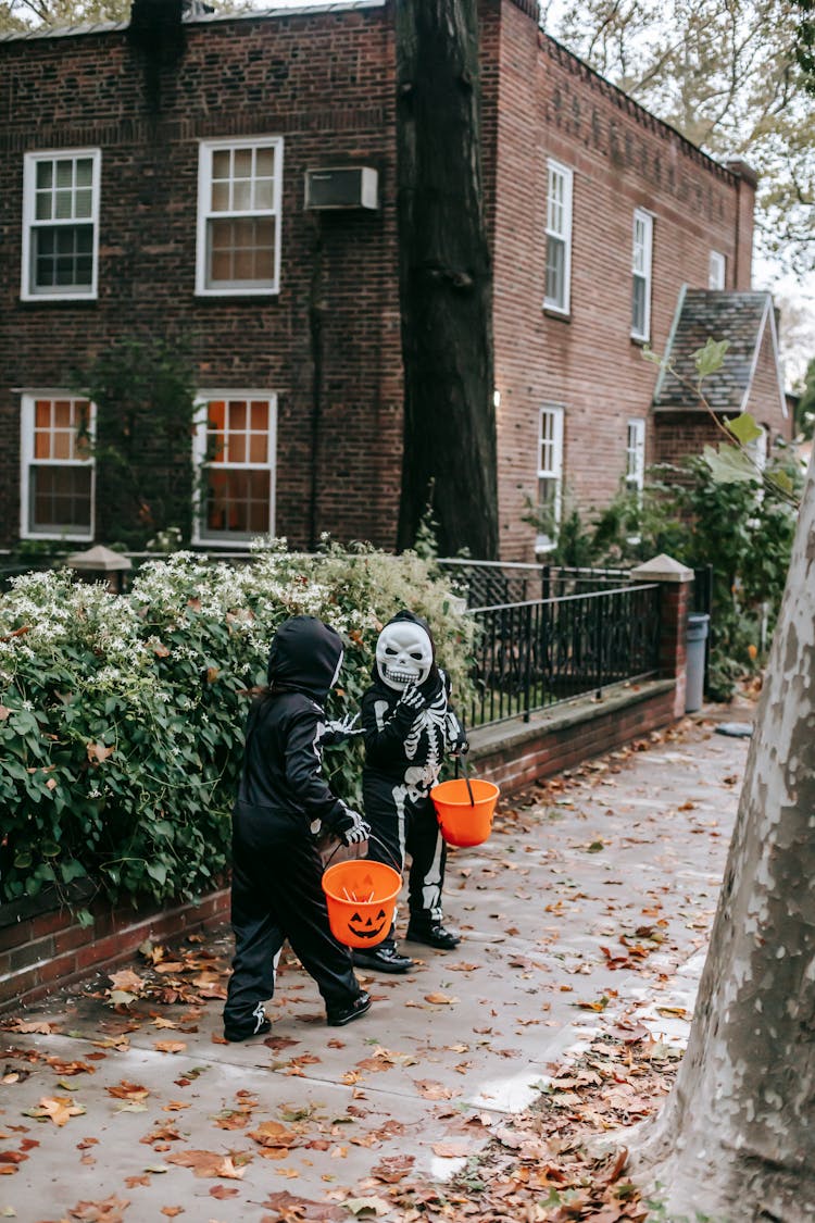 Faceless Kids Trick Or Treating In Halloween Costumes In Street