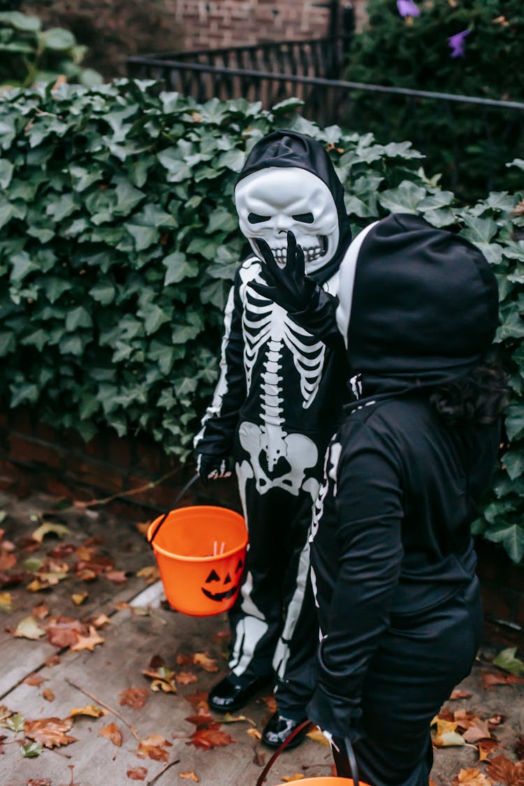 Anonymous Children Standing On Sidewalk In Halloween Costumes