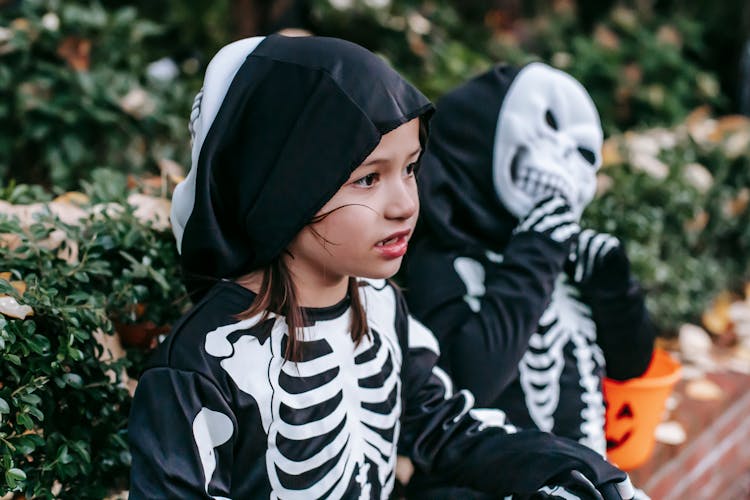 Cute Little Preschool Girl Sitting Near Garden With Friend Wearing Scary Costume