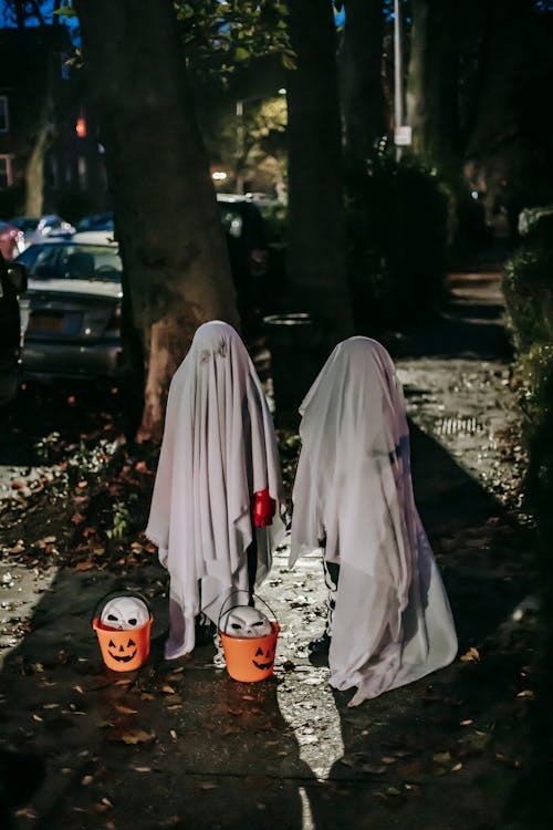 Child dressed like Halloween ghost standing in dark street · Free Stock ...