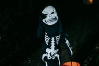 Unrecognizable kid in skeleton costume during Halloween