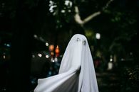 万圣节晚上，一个孩子穿着幽灵服装在户外