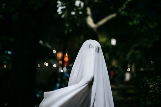 万圣节晚上，一个孩子穿着幽灵服装在户外
