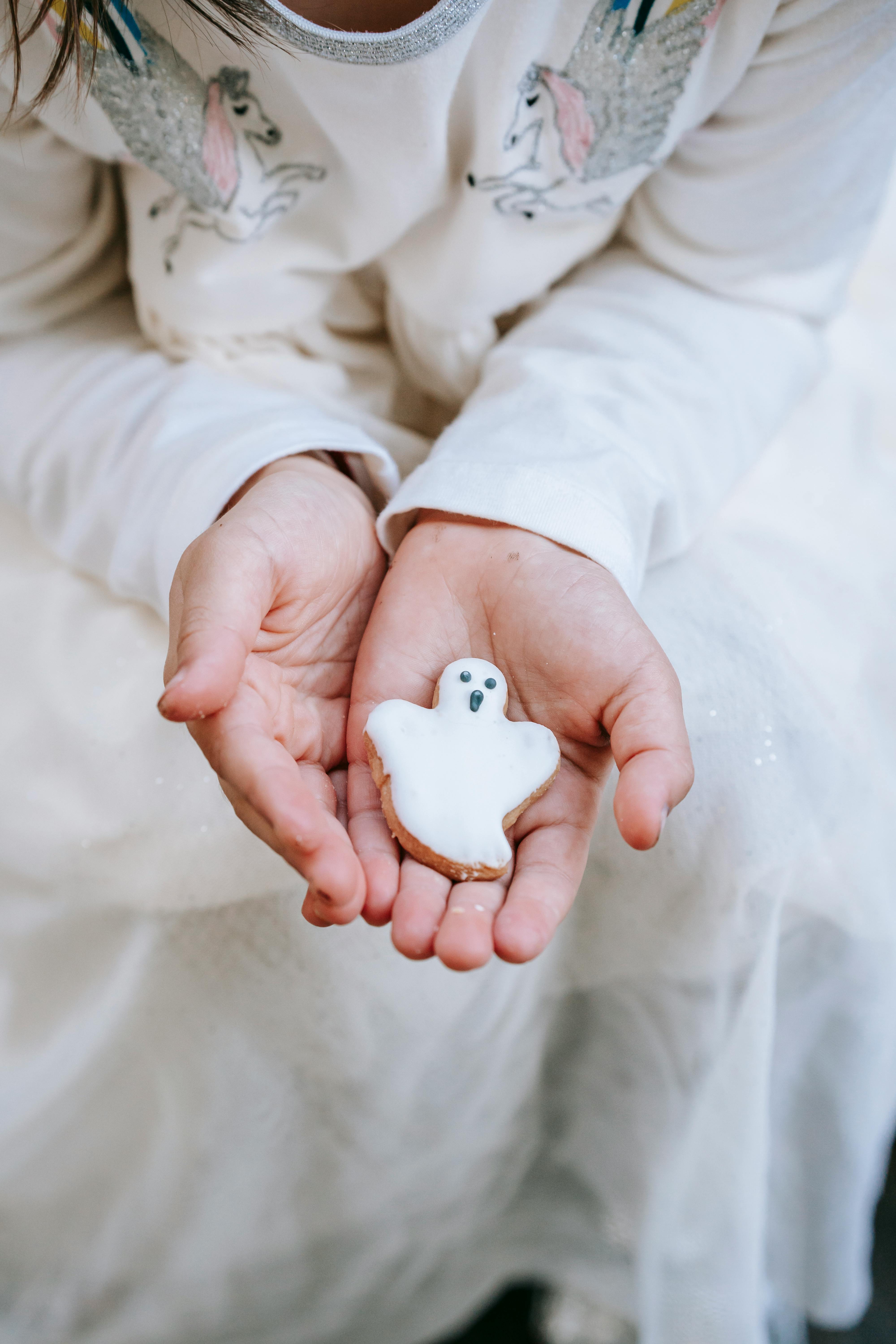 crop faceless girl demonstrating ghost cookie on hand