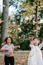 一个穿着休闲服、来自多民族的女孩，在晴朗的秋日公园里愉快地抛洒着黄色的落叶，一起玩耍