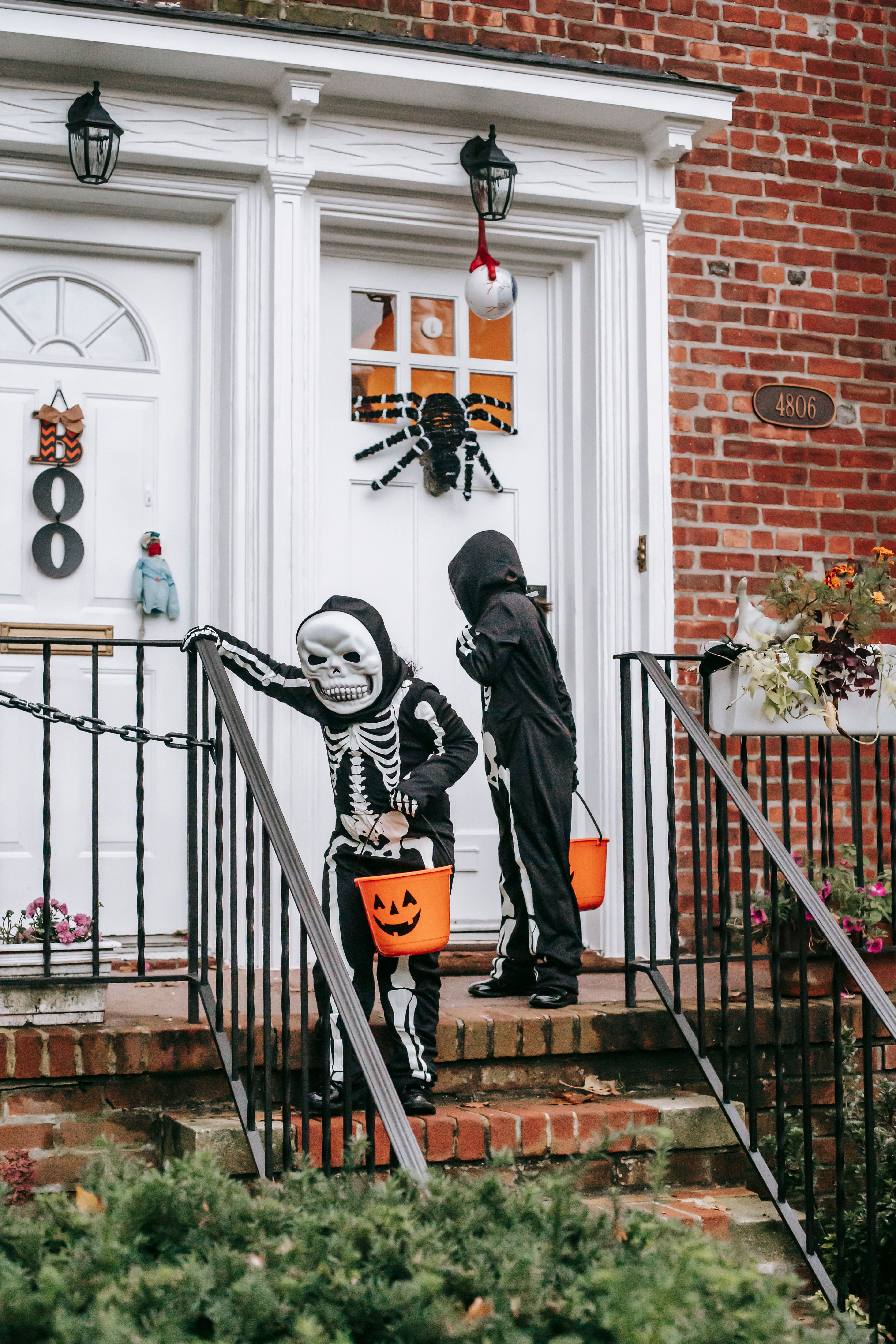 孩子们在一所装饰好的房子里，穿着骷髅服装玩“不给糖就捣蛋”的游戏
