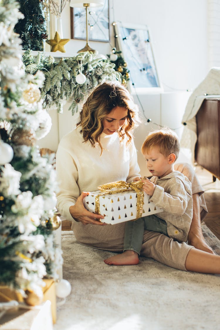 Child And Woman Looking At A Gift