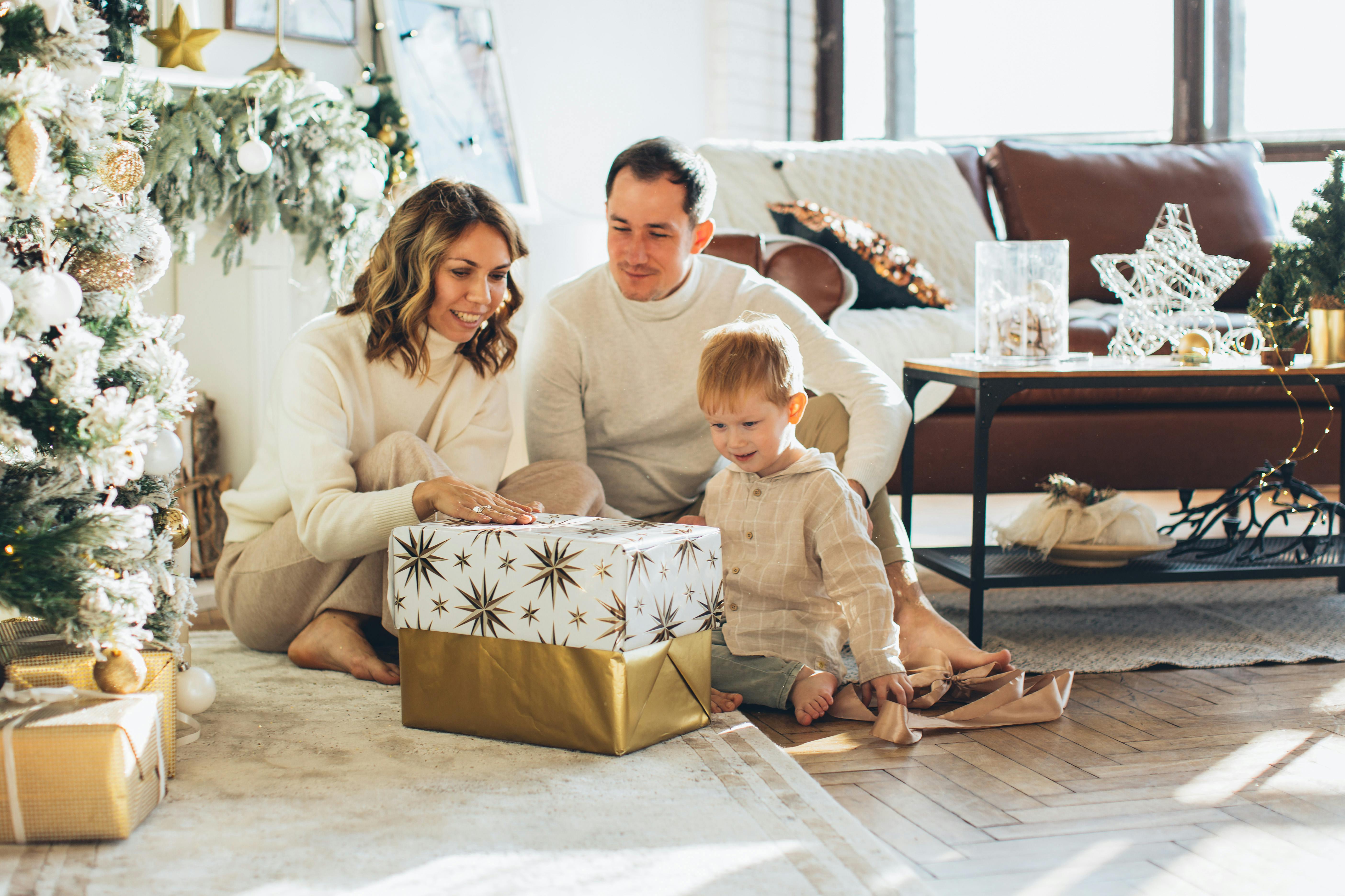 Family opening Christmas presents together in a festive decorated living room.