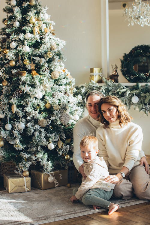 Free Family Sitting Beside a Christmas Tree Stock Photo