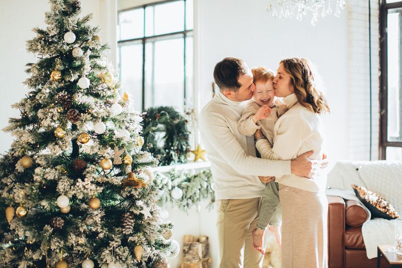 A joyful family embraces near a beautifully decorated Christmas tree during the festive season.