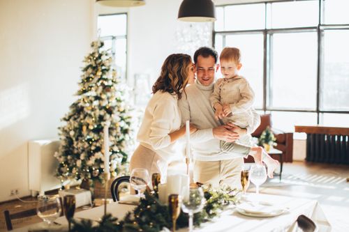 Free A happy family gathered around the table enjoying a cozy Christmas indoors. Stock Photo