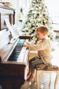 Boy in White and Brown Stripe Long Sleeve Shirt Playing Piano