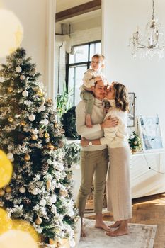 一对快乐的夫妇和他们的孩子在室内庆祝圣诞节
