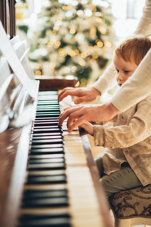 Boy in White Long Sleeve Shirt Playing Piano