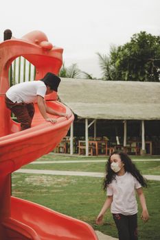Children playing on a spiral slide in Riau Islands, Indonesia, during daytime.