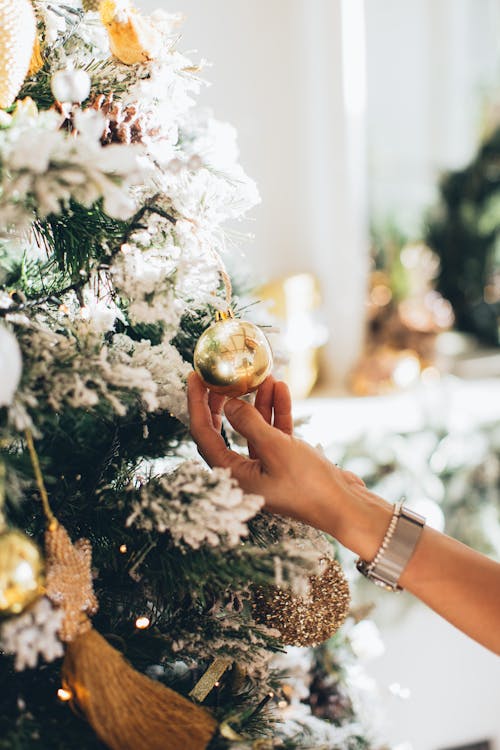 A Person Holding a Gold Christmas Bauble 