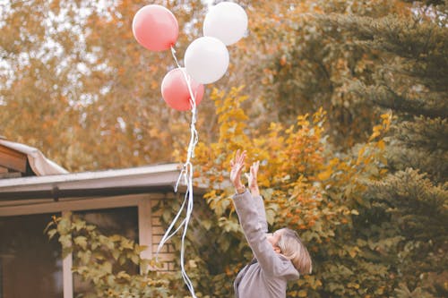 Free Woman in Gray Jacket Released Balloons in the Air Stock Photo