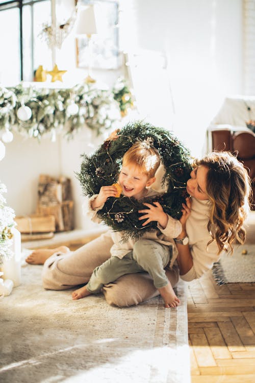 Free Mother and Child Playing with the Christmas Wreath Stock Photo